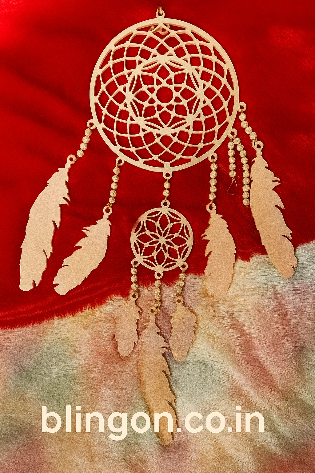 Beige dreamcatcher with intricate circular web and feather tassels hanging on a red background, with a 'blingon.co.in' watermark at the bottom.
